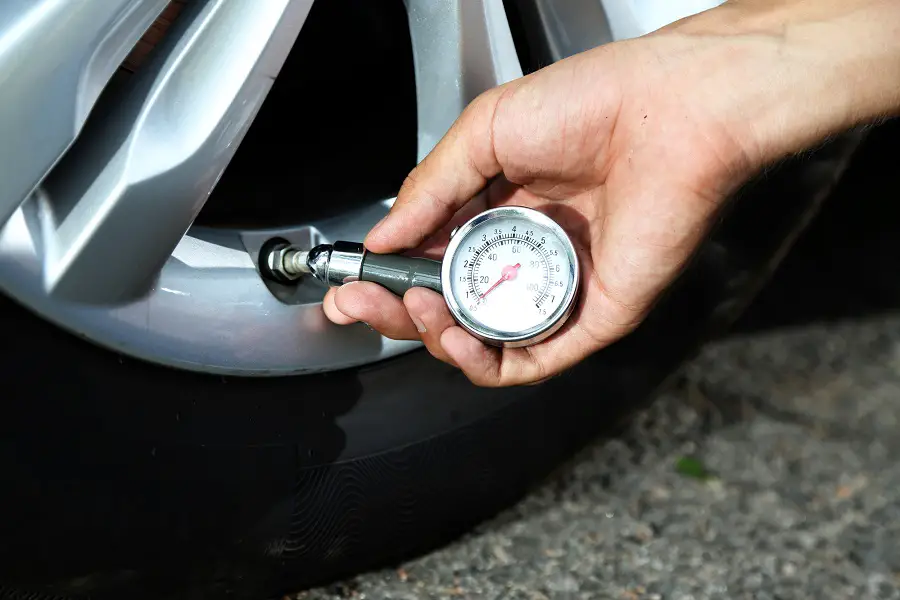checking tire pressure with a dial gauge