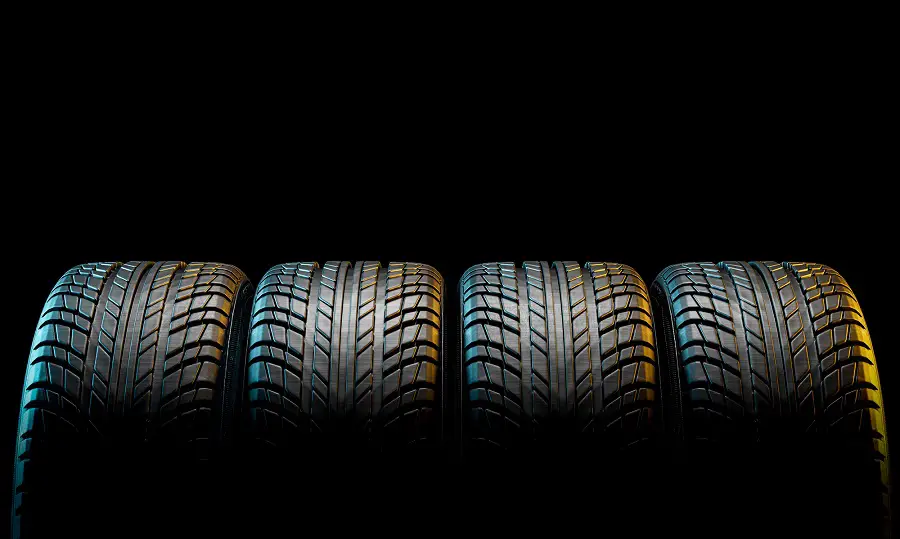 Four Matching Tires on Black Background