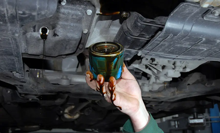 mechanic doing an oil change old oil filter